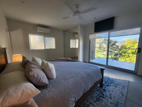 a bedroom with a bed and a large window at The Shed House in Mount Beauty