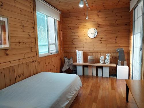 a bedroom with a bed and a table and a clock at Art Residency in Busan