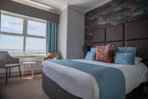 a bedroom with a large bed with a painting on the wall at Camelia Hotel in Southend-on-Sea