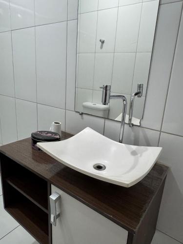 a bathroom with a white sink and a mirror at Apartamento individual in Ipatinga