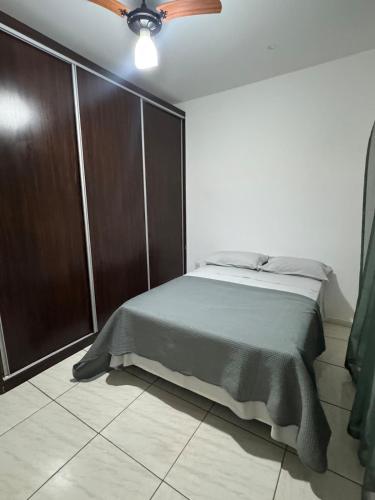 a bedroom with a bed and a ceiling fan at Apartamento individual in Ipatinga