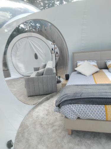 a bedroom with a bed and a round mirror at La Bulle des Brosses étoilées in Igé