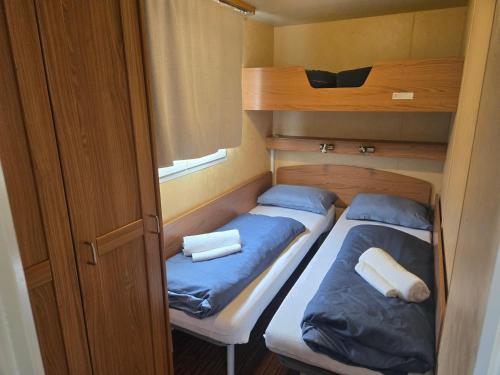 two bunk beds in a small room with blue pillows at Kopićland HOMES in Marinci