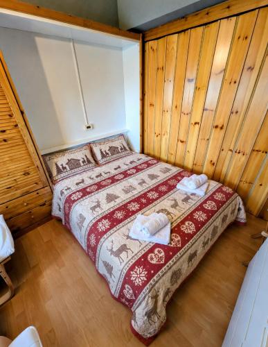 a bedroom with a bed in a room with wooden walls at "FamilyNest" by Staymarilleva1400 in Marilleva