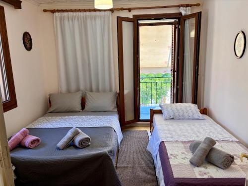 two beds in a room with a window at Diamanti Stone House in Lafiónas