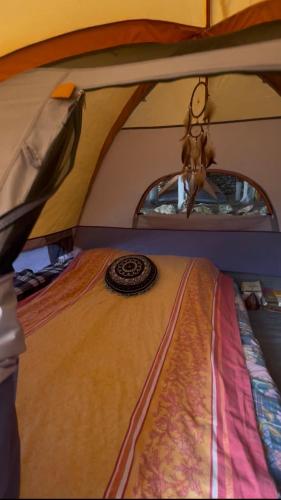 a bed in a tent in a room at The Sea Turtle Camp in Dhërmi