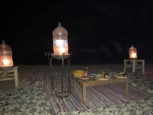a table with food on it with two lights on it at La Basha Camp in Dahab