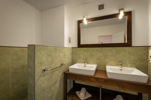 a bathroom with two sinks and a mirror at Serenity Residence Hotel & Wellness in Liptovský Trnovec
