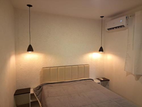 a bedroom with two lights above a bed at espaço completo só para você e seus familiares in Gravatá
