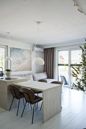 a kitchen and living room with a table and chairs at Apartamenty Blanca in Łeba