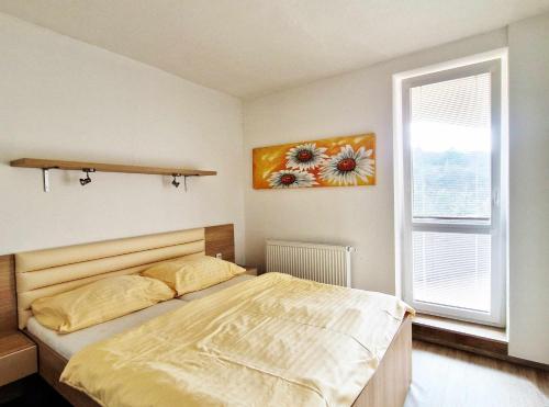 a bedroom with a bed and a painting on the wall at Apartmán Všemina 346 in Všemina