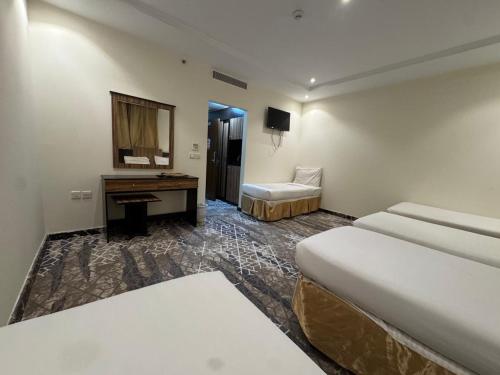 a hotel room with two beds and a desk at فندق اسرار التيسير in Mecca