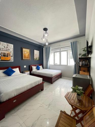 a bedroom with two beds and a blue wall at Khách Sạn Cây Xanh in Da Lat