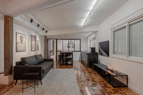 a living room with a couch and a tv at Estúdio 196 in Bento Gonçalves