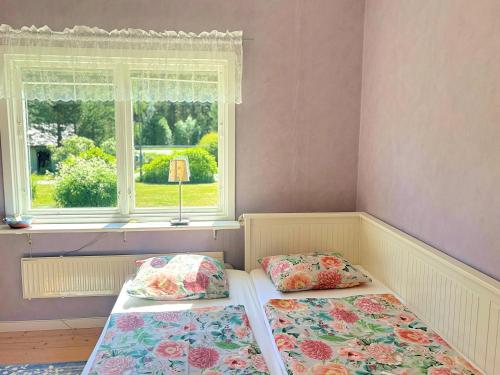 two beds in a room with a window at Hus Indalsälven in Hammarstrand