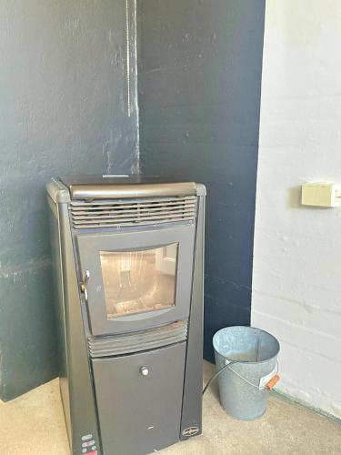 a small stove in a room with a bucket at Hus Indalsälven in Hammarstrand