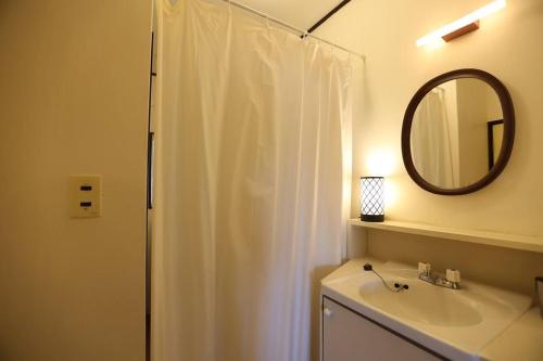 a bathroom with a shower curtain and a sink at 木漏れ日の森で都会では味わえない静寂を那須の自然を満喫する貸別荘つつじ山 in Nasu