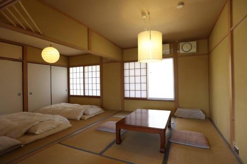 a room with two beds and a table in it at 木漏れ日の森で都会では味わえない静寂を那須の自然を満喫する貸別荘つつじ山 in Nasu