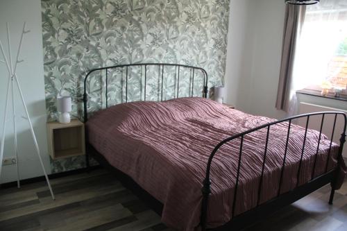 a bedroom with a bed with a purple comforter at Ferienwohnung Moin Eifel in Schleiden