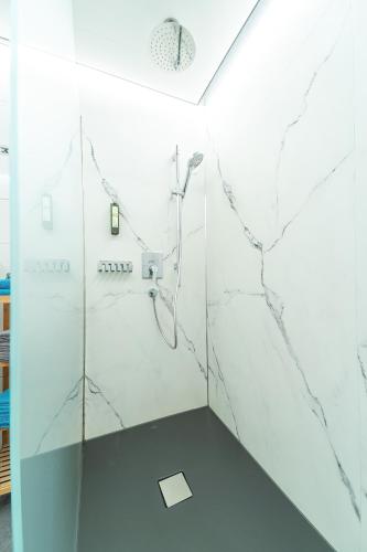 a bathroom with a shower with marble walls at Haus Muntschnei in Sankt Gallenkirch