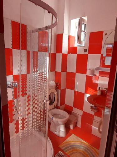a red and white bathroom with a toilet and a shower at Casa Carlo in Eforie Nord