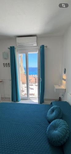 a bedroom with a blue bed with a view of the ocean at Amore di Mare in Cagliari