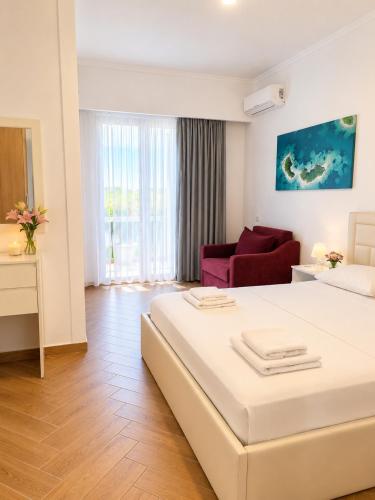 a hotel room with a large bed and a couch at Vasiliu Boutique Hotel Ksamil in Ksamil