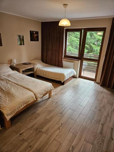 a hotel room with two beds and a window at Pokoje DARMAT in Stegna