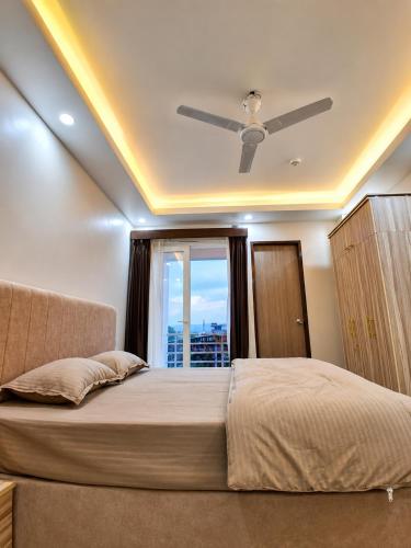 a bedroom with a bed with a ceiling fan at Hotel Silver Oak in Dehradun