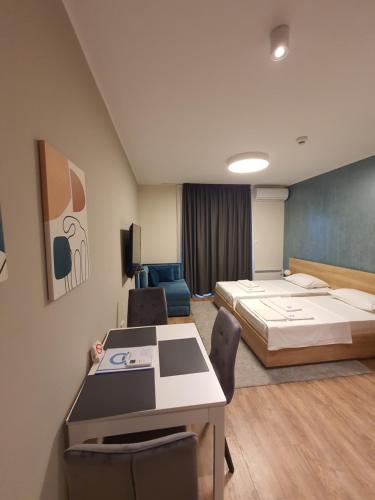 a room with two beds and a table and chairs at Omega Dom in Vrnjačka Banja