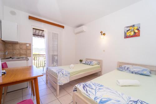 a small room with two beds and a kitchen at Protić Apartments in Vela Luka