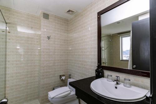 a bathroom with a sink and a toilet and a mirror at Rico hotel Nha Trang in Nha Trang