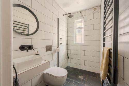 a bathroom with a toilet and a sink and a mirror at Ebenezer Hall in Falmouth