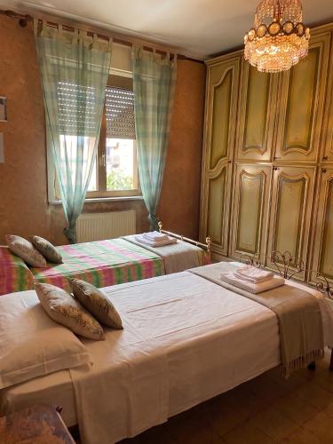 a bedroom with two beds and a chandelier at Tra le vie di Todi in Todi