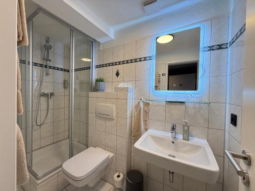 a bathroom with a sink and a toilet and a shower at Pinnø - Padel Hotel Food in Pinnow