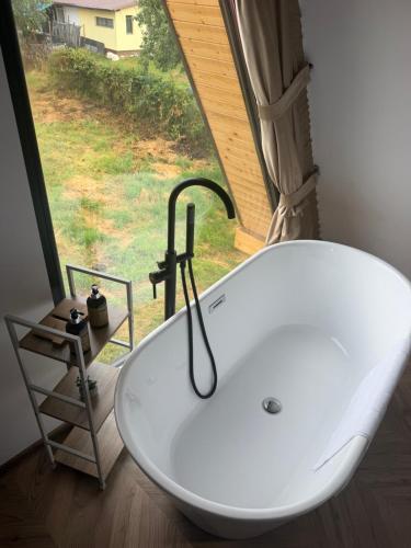 a white bath tub in a bathroom with a window at Noora Nook in Sadu
