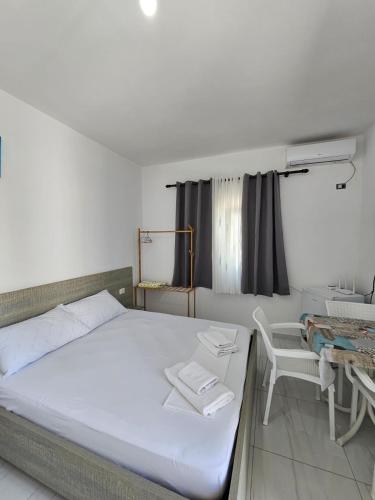 a bedroom with a bed and a chair and a window at Troi beach house in Vlorë