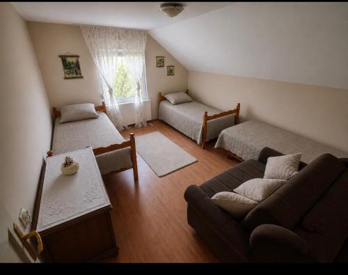 a living room with two beds and a couch at HERC domaćinstvo in Nova Varoš