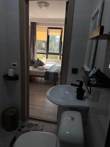 a bathroom with a toilet and a sink and a bed at River guest house in Osh