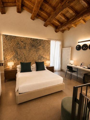 a bedroom with a large white bed in a room at Albergo Diffuso Ginevra Boutique Rooms - Palazzo Leosini - Residenze D'Epoca in LʼAquila