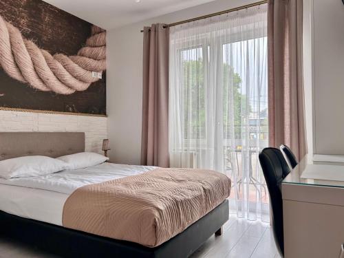 a bedroom with a bed and a large window at Perełka Bałtyku in Władysławowo