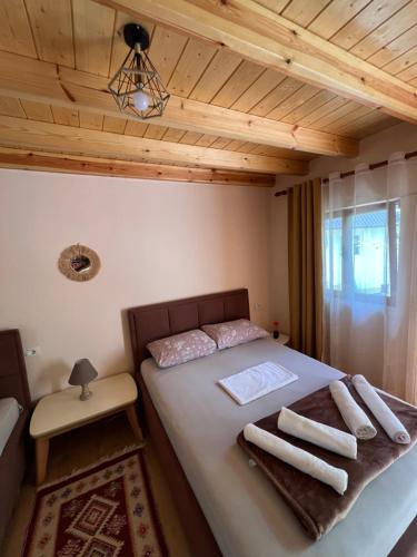 a bedroom with a bed with towels on it at Guest House Shtëpiza Theth in Theth