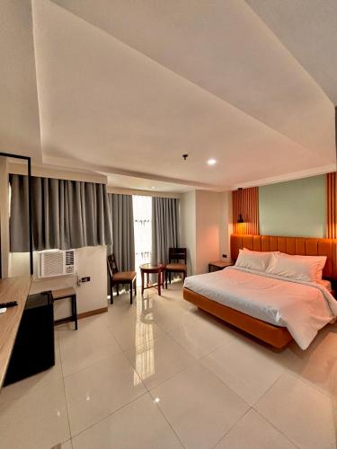 a hotel room with a bed and a desk and a desk at Hotel Rodolfo in Tacloban