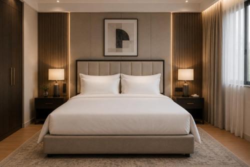 a bedroom with a large white bed with two lamps at Hotel Airport Elite Suit Near Delhi Airport in New Delhi