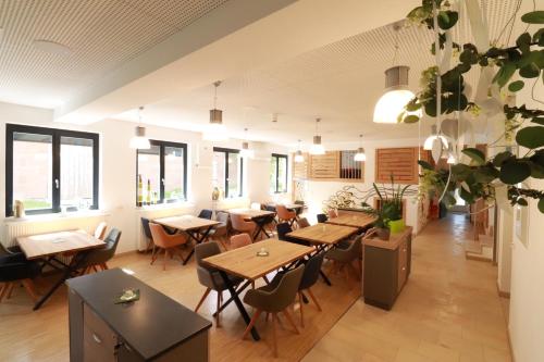 a restaurant with wooden tables and chairs and windows at alla Papa in Obernzenn