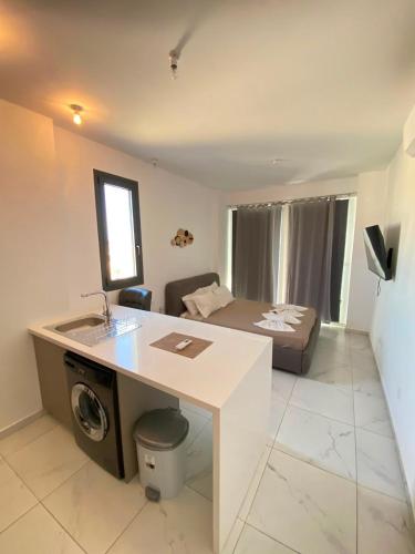 a kitchen and living room with a sink and a bed at Sea view Penthouse Universal Residences in Paphos