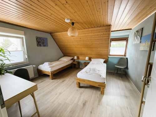 a room with two beds and a wooden ceiling at Gästewohnung in Algermissen in Algermissen