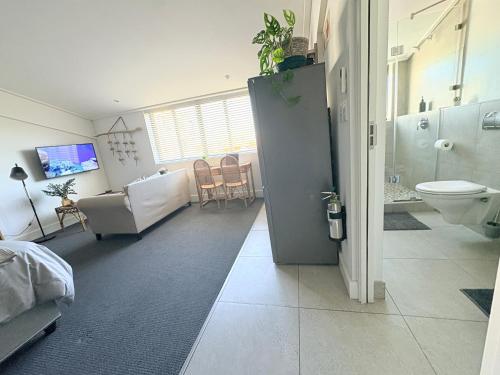 a room with a bathroom with a toilet and a sink at Hermanus Waterfront Boho Studio Apartment, Whale Coast Hideaway in Hermanus
