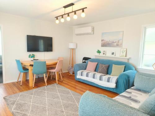 a living room with a couch and a table at Lake, mountain view cottage - near major attractions in Rotorua