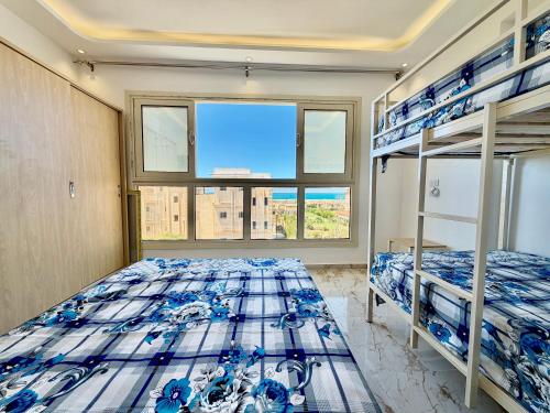 a bedroom with two bunk beds and a window at Sea & Pool View Deluxe Chalet - Prime Spot in Badr Resort in El Alamein